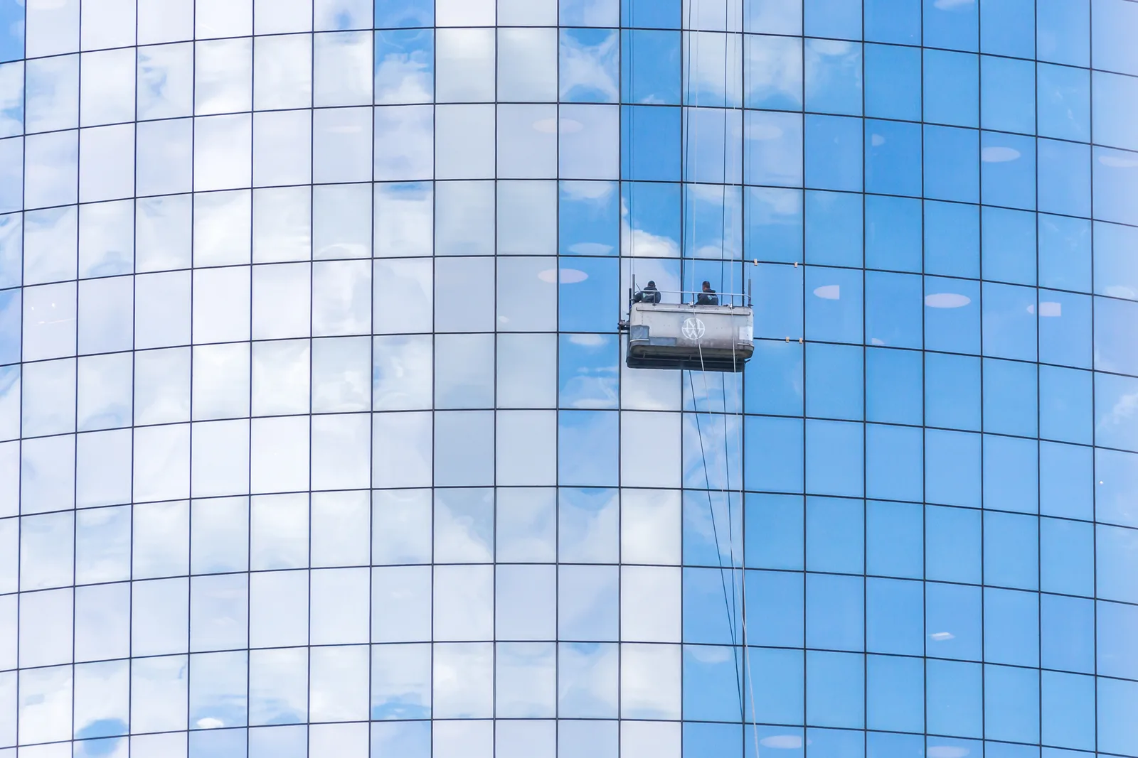 Window cleaner working on commercial glass at height