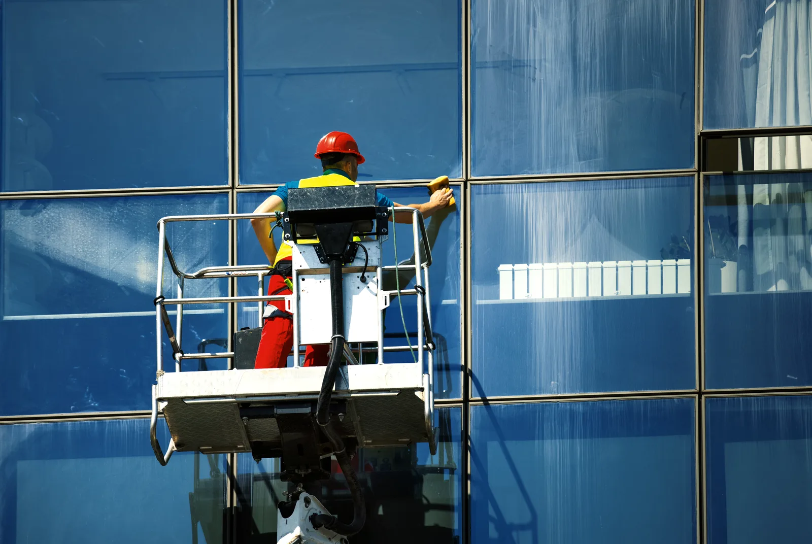 Window cleaner working from a lift on a commercial glass facade